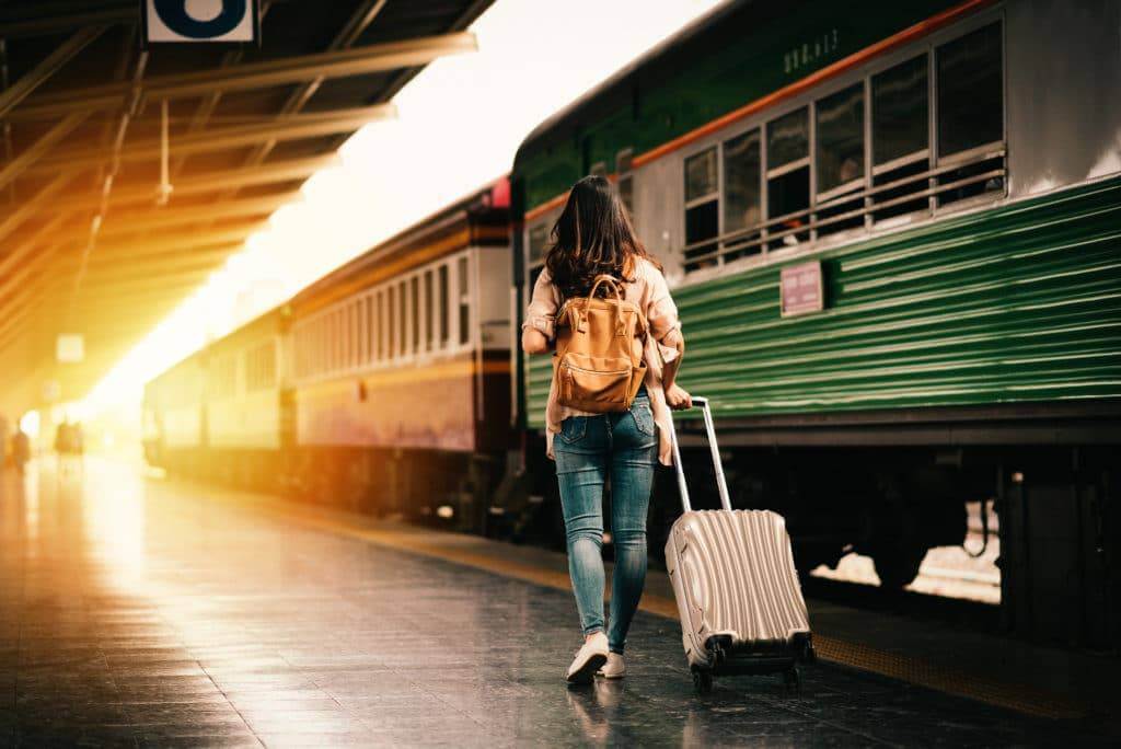 Woman with a suitcase walking by a train