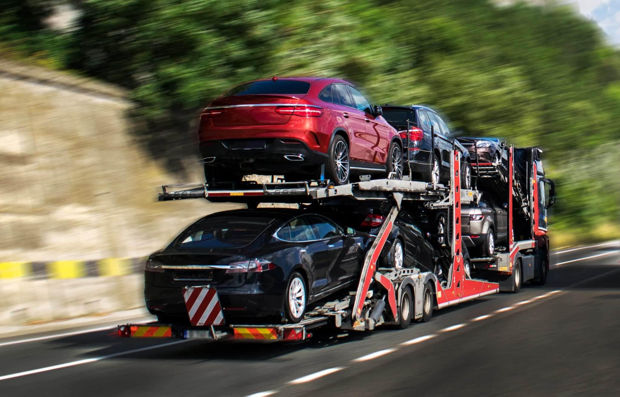 Open carrier transporting cars on a highway