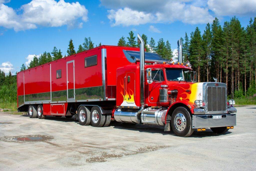 Large red Semi-Truck and trailer. In the auto transport industry, there are two main transport options. Open car transport and enclosed auto transport. Whether you have a luxury vehicle or a classic car, we provide excellent customer service.