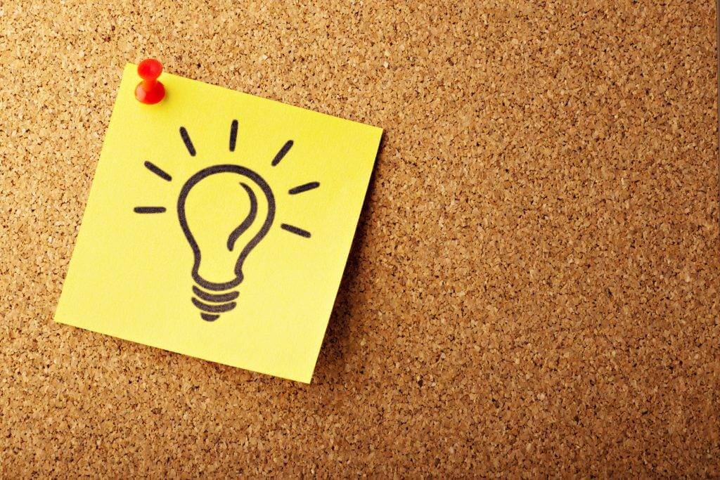 A yellow post-it note with a light bulb drawn on it. Pinned to a corkboard. Car Shipping Cost: Everything You Need To Know