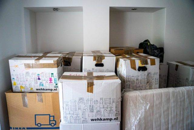 A bedroom filled with packed moving boxes. Moving pod service.