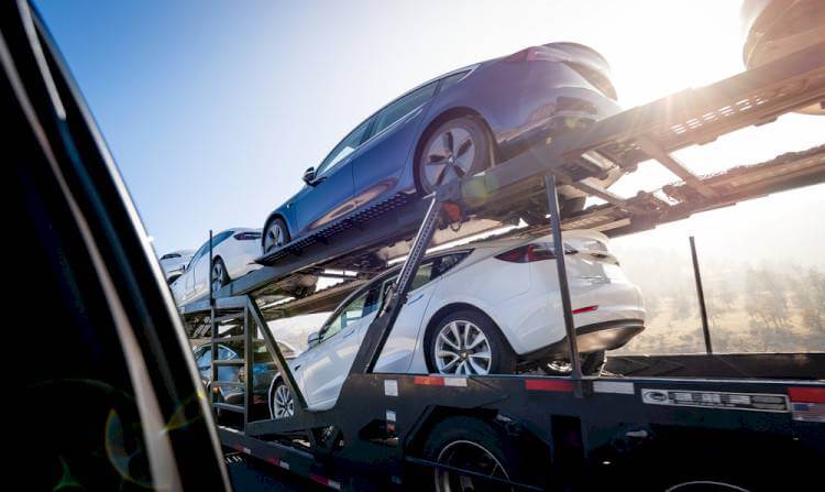 A close-up view of vehicles held on a car carrier trailer. Contact us today to find out how long does it take to ship a car.