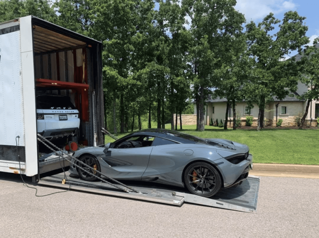 A dark grey McLaren loading into an enclosed car trailer. Exotic car transport, Luxury car transport, and classic car transport, we can help you with all levels of automobiles. We are the car shipping company for luxury cars.