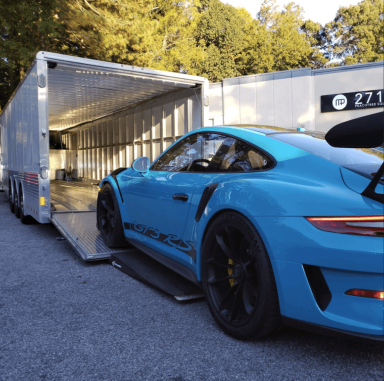 A Light Blue Porsche is loaded into an enclosed trailer. If you need to ship a car, we are the best car shipping company around. Ask about our —Door-to-door Auto Transport Service.