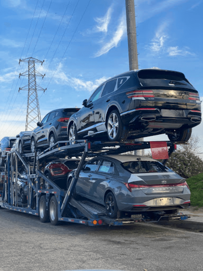 An open car trailer with new cars loaded.