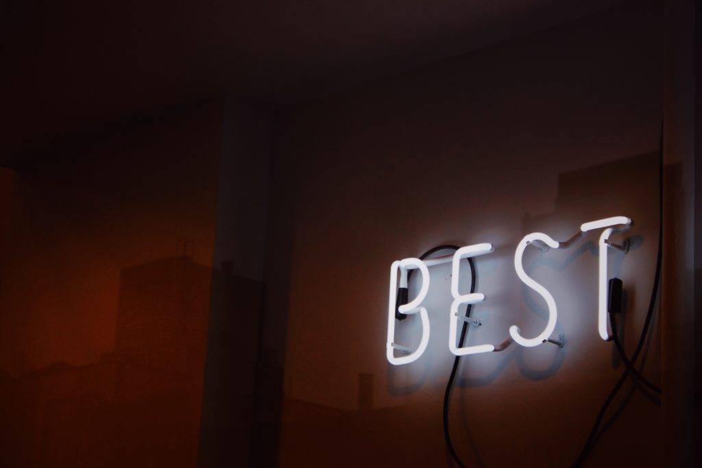 Neon sign that says, BEST. National Transport Services is the best car shipping company.