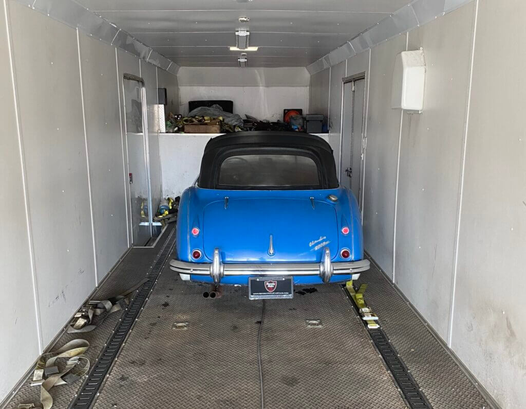 An electric blue 1960s Austin-Healey loaded inside a two-car covered transport trailer. If you're looking for a reliable enclosed car shipping company, you have come to the right place! Considering some key factors - reputation, experience, insurance and quotation-can make all the difference in ensuring the right enclosed auto transport company completes the job without issue.