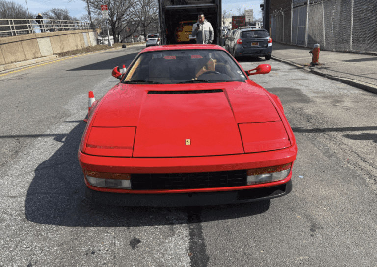 A red 1987 Ferrari Testarossa was just unloaded from an enclosed car transport trailer. We can move any car across the country, new or vintage, exotic car, or daily drivers.