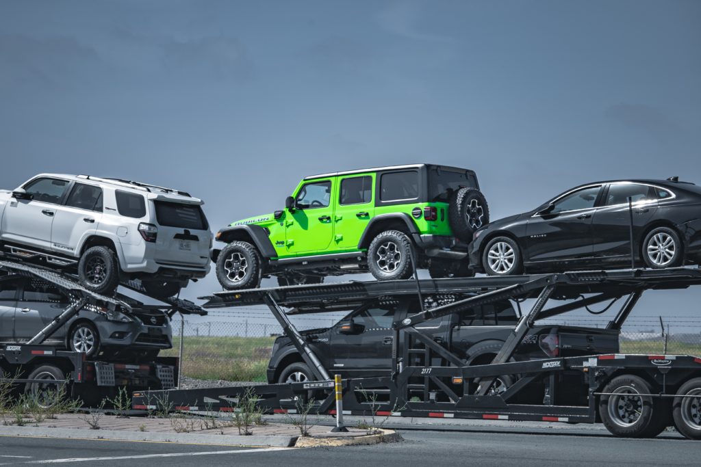 Multi-car transport trailer with five vehicles loaded—long-distance towing. Long-distance car towing is a safe and convenient way to move vehicles nationwide. Our Car towing services are available in all 50 states. 