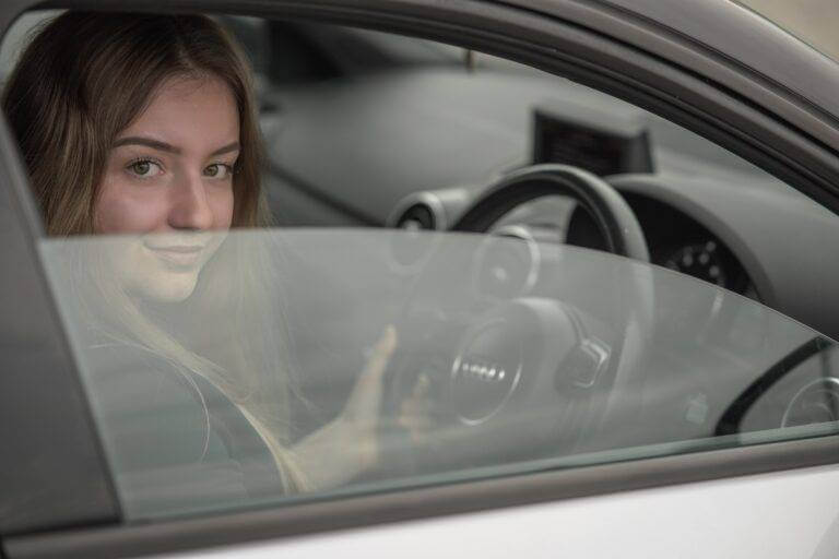 Woman in the driver seat of her car. As the leading car shipping company, we service everyone from College students to family moves, military relocation, and snowbirds.