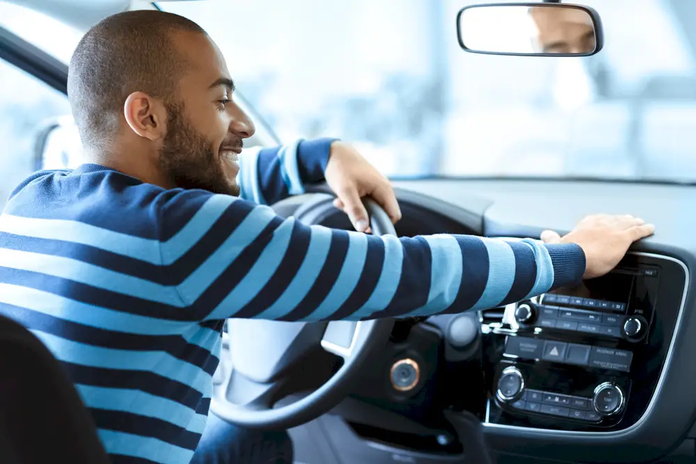 Happy car owner behind the wheel. Choose a reliable auto transport company by contacting National Transport Services today!