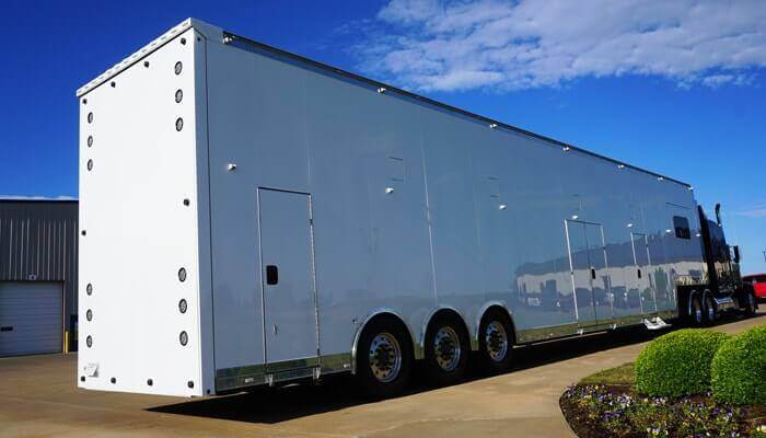 a 6-car enclosed auto transport trailer in white.